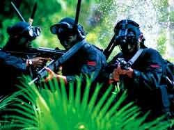 Indonesian soldiers pointing guns in different directions.